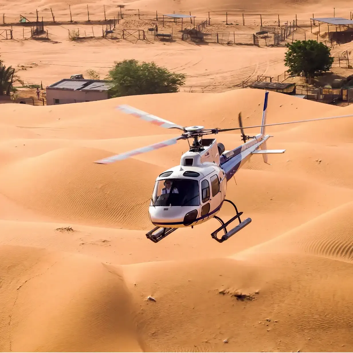 Helicopter cruising low over the Dubai desert dunes