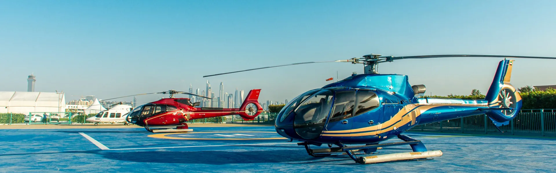 Two Helicopter Ride Dubai helicopters on a Dubai helipad with the Marina skyline behind